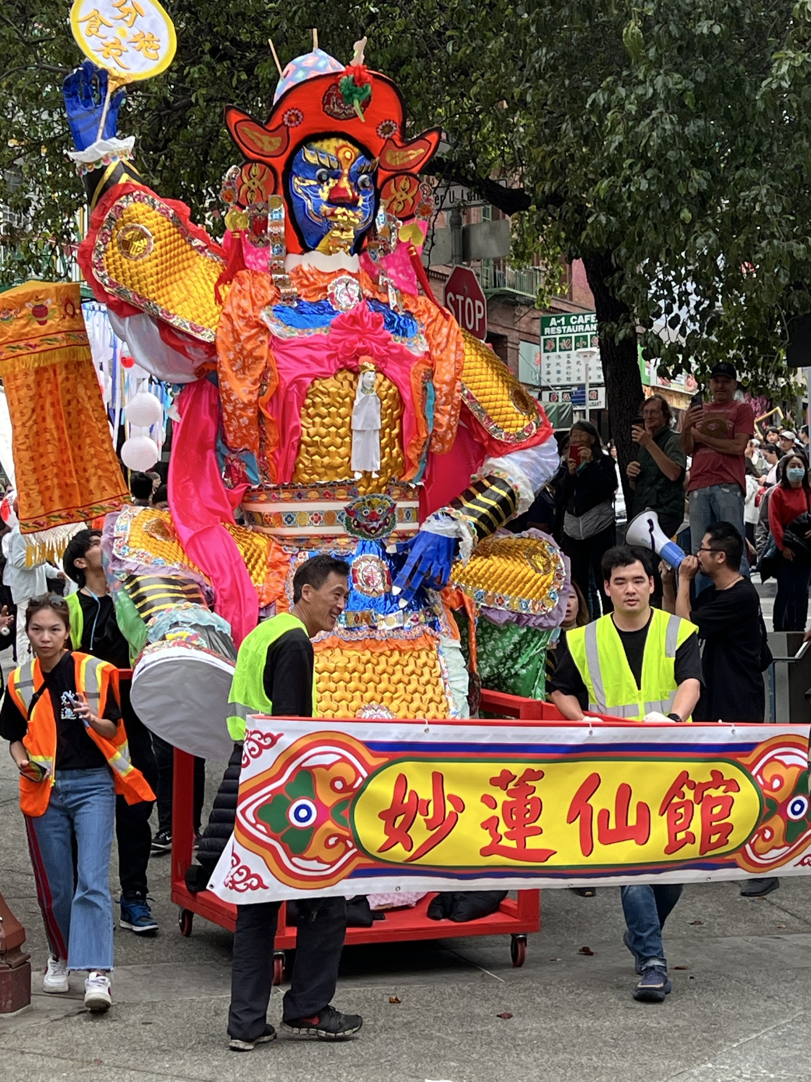 Colorful Hungry Ghost Parade figure surrounded by event staff and spectators