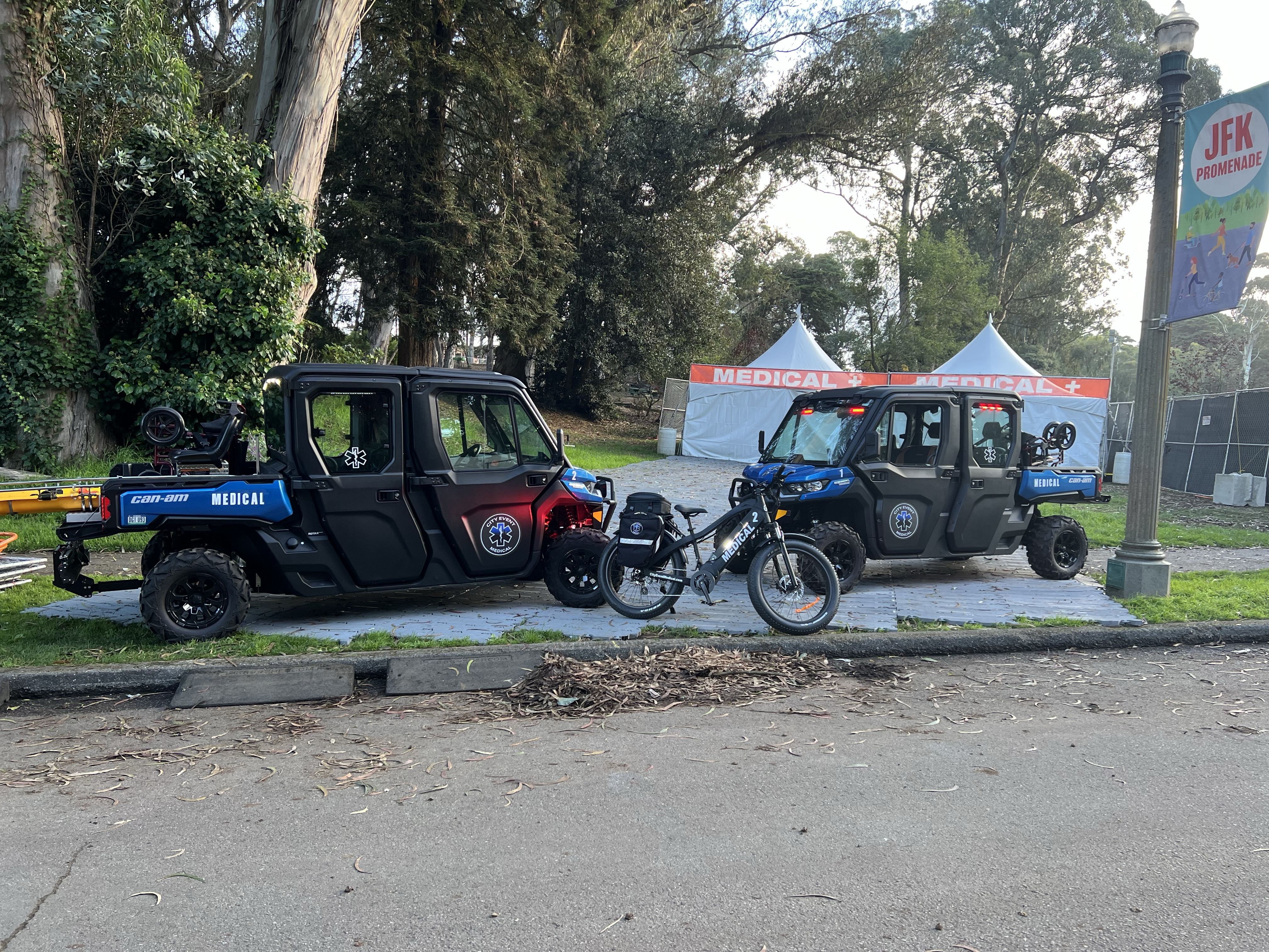 City Event Medical’s two blue medical UTVs and equipped e-bike stationed beside medical tents